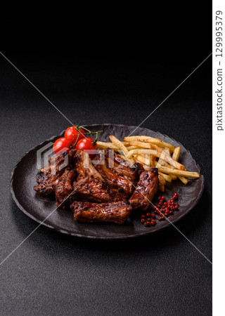 Meat, beef ribs in a marinade grilled with salt and spices. Grilled ribs Meat, beef ribs in a marinade grilled with salt and spices. Grilled ribs 129995379