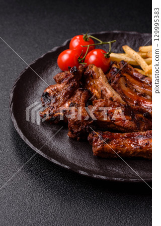 Meat, beef ribs in a marinade grilled with salt and spices. Grilled ribs Meat, beef ribs in a marinade grilled with salt and spices. Grilled ribs 129995383