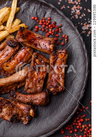 Meat, beef ribs in a marinade grilled with salt and spices. Grilled ribs Meat, beef ribs in a marinade grilled with salt and spices. Grilled ribs 129995386