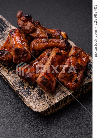 Meat, beef ribs in a marinade grilled with salt and spices. Grilled ribs Meat, beef ribs in a marinade grilled with salt and spices. Grilled ribs 129995403