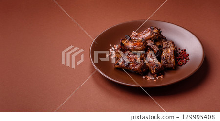 Meat, beef ribs in a marinade grilled with salt and spices. Grilled ribs Meat, beef ribs in a marinade grilled with salt and spices. Grilled ribs 129995408