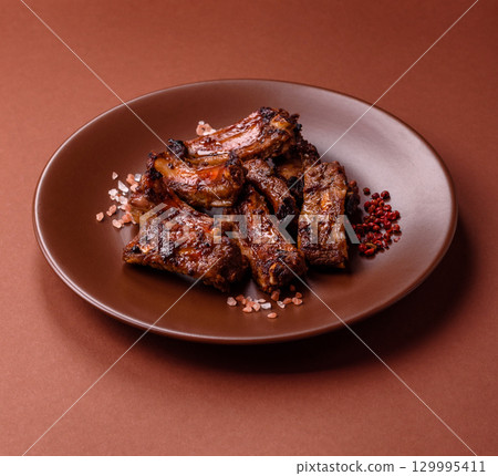 Meat, beef ribs in a marinade grilled with salt and spices. Grilled ribs Meat, beef ribs in a marinade grilled with salt and spices. Grilled ribs 129995411