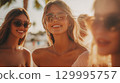 Three beautiful women enjoying their time at summer, all smiles. A group of girlfriends in a sunny day sunshine at the beach. They're smiling and wearing sunglasses. This is AI-generated item 129995757
