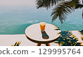 A refreshing drink on a table by the pool on a sunny day, perfect for relaxing. A refreshing drink sits on a table, next to a pool. Sunlight filters through the palms This is AI-generated item 129995764