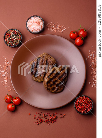 Grilled beef steak meat with salt and pepper. Beef steak grilled on a barbecue Grilled beef steak meat with salt and pepper. Beef steak grilled on a barbecue 129995819