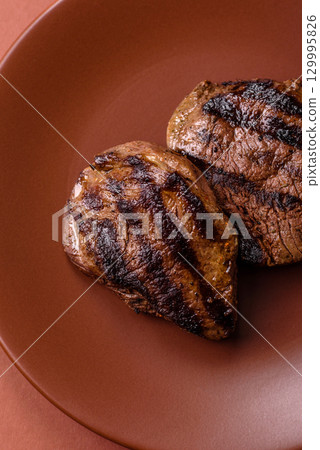 Grilled beef steak meat with salt and pepper. Beef steak grilled on a barbecue Grilled beef steak meat with salt and pepper. Beef steak grilled on a barbecue 129995826