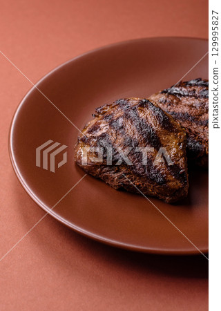 Grilled beef steak meat with salt and pepper. Beef steak grilled on a barbecue 129995827