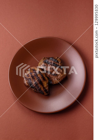 Grilled beef steak meat with salt and pepper. Beef steak grilled on a barbecue Grilled beef steak meat with salt and pepper. Beef steak grilled on a barbecue 129995830