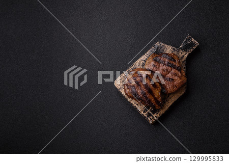 Grilled beef steak meat with salt and pepper. Beef steak grilled on a barbecue 129995833