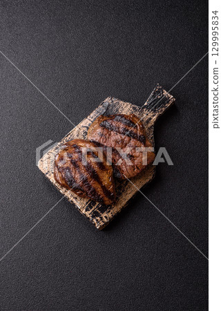 Grilled beef steak meat with salt and pepper. Beef steak grilled on a barbecue 129995834