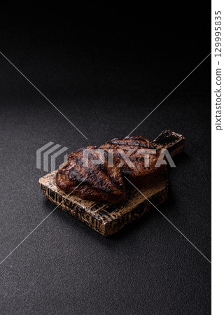 Grilled beef steak meat with salt and pepper. Beef steak grilled on a barbecue Grilled beef steak meat with salt and pepper. Beef steak grilled on a barbecue 129995835