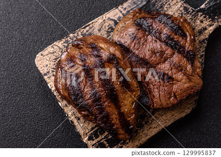 Grilled beef steak meat with salt and pepper. Beef steak grilled on a barbecue 129995837