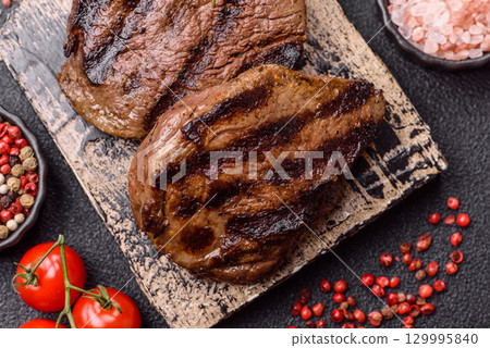 Grilled beef steak meat with salt and pepper. Beef steak grilled on a barbecue Grilled beef steak meat with salt and pepper. Beef steak grilled on a barbecue 129995840