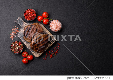 Grilled beef steak meat with salt and pepper. Beef steak grilled on a barbecue 129995844