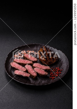 Grilled beef steak meat with salt and pepper. Beef steak grilled on a barbecue 129995850
