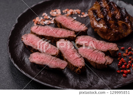 Grilled beef steak meat with salt and pepper. Beef steak grilled on a barbecue 129995851