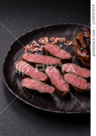 Grilled beef steak meat with salt and pepper. Beef steak grilled on a barbecue Grilled beef steak meat with salt and pepper. Beef steak grilled on a barbecue 129995854