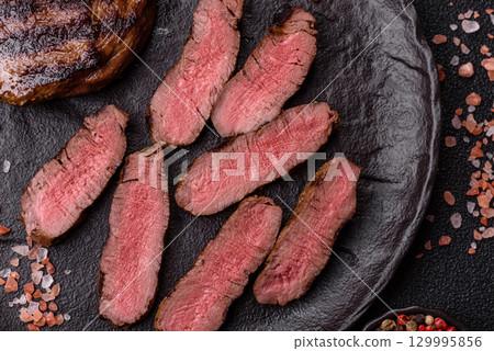 Grilled beef steak meat with salt and pepper. Beef steak grilled on a barbecue Grilled beef steak meat with salt and pepper. Beef steak grilled on a barbecue 129995856