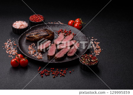 Grilled beef steak meat with salt and pepper. Beef steak grilled on a barbecue Grilled beef steak meat with salt and pepper. Beef steak grilled on a barbecue 129995859