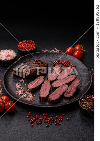 Grilled beef steak meat with salt and pepper. Beef steak grilled on a barbecue Grilled beef steak meat with salt and pepper. Beef steak grilled on a barbecue 129995862