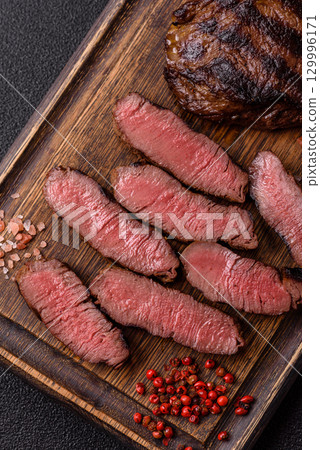 Grilled beef steak meat with salt and pepper. Beef steak grilled on a barbecue Grilled beef steak meat with salt and pepper. Beef steak grilled on a barbecue 129996171