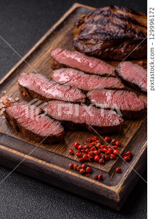 Grilled beef steak meat with salt and pepper. Beef steak grilled on a barbecue 129996172