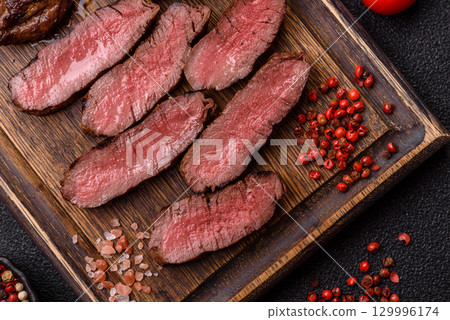 Grilled beef steak meat with salt and pepper. Beef steak grilled on a barbecue Grilled beef steak meat with salt and pepper. Beef steak grilled on a barbecue 129996174