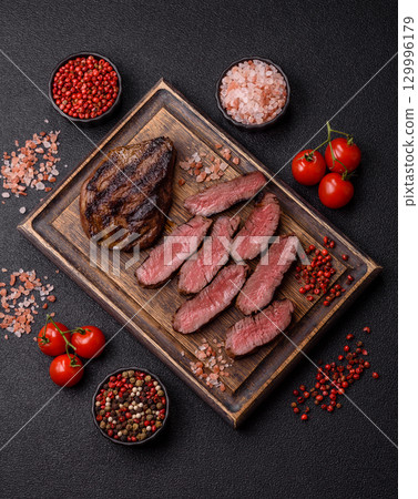 Grilled beef steak meat with salt and pepper. Beef steak grilled on a barbecue Grilled beef steak meat with salt and pepper. Beef steak grilled on a barbecue 129996179