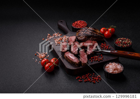 Grilled beef steak meat with salt and pepper. Beef steak grilled on a barbecue Grilled beef steak meat with salt and pepper. Beef steak grilled on a barbecue 129996181