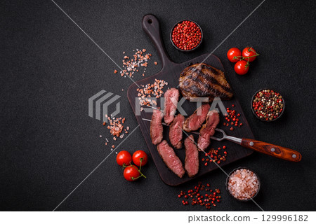 Grilled beef steak meat with salt and pepper. Beef steak grilled on a barbecue Grilled beef steak meat with salt and pepper. Beef steak grilled on a barbecue 129996182