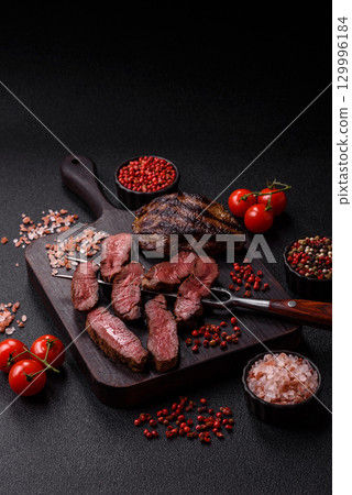 Grilled beef steak meat with salt and pepper. Beef steak grilled on a barbecue 129996184