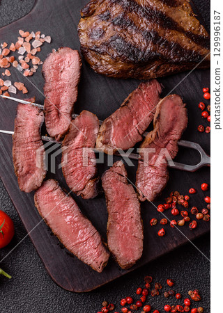 Grilled beef steak meat with salt and pepper. Beef steak grilled on a barbecue Grilled beef steak meat with salt and pepper. Beef steak grilled on a barbecue 129996187