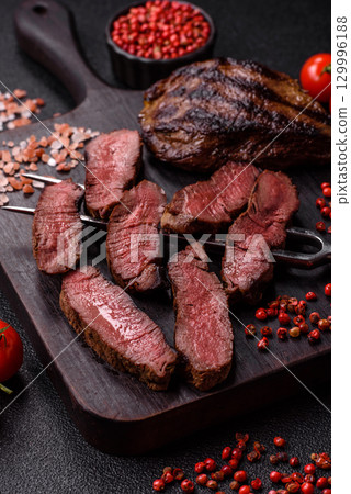 Grilled beef steak meat with salt and pepper. Beef steak grilled on a barbecue Grilled beef steak meat with salt and pepper. Beef steak grilled on a barbecue 129996188