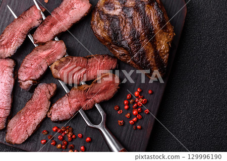 Grilled beef steak meat with salt and pepper. Beef steak grilled on a barbecue 129996190