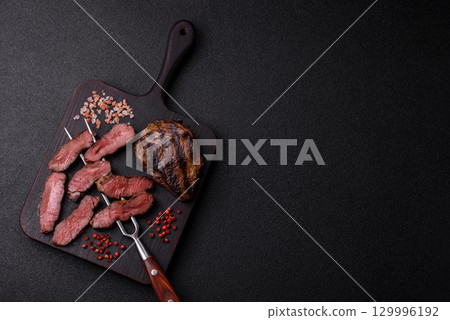 Grilled beef steak meat with salt and pepper. Beef steak grilled on a barbecue Grilled beef steak meat with salt and pepper. Beef steak grilled on a barbecue 129996192