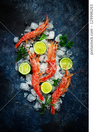 Langoustines, Australian, freshly frozen on ice, top view, lime and greens, 129996263