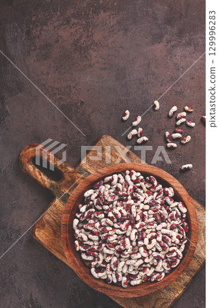 variegated beans, red with white spots, raw in a wooden bowl, top view, no people, 129996283