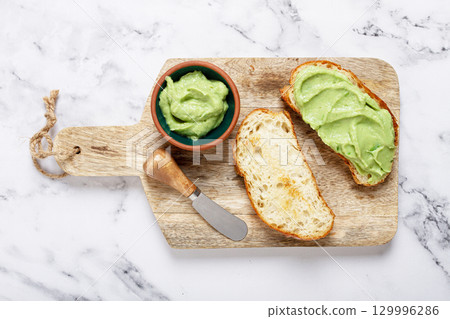 Ciabatta with avocado pasta, breakfast, on a chopping board, top view, homemade, no people, 129996286