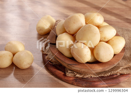 boiled new potatoes, in a wooden bowl, on a rustic table, natural light, no people, 129996304