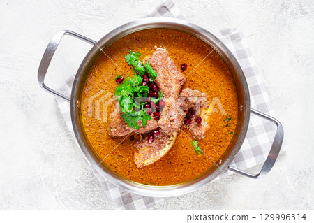 fesenjan, an Iranian dish, stewed chicken, in a nut-pomegranate sauce, in a saucepan,light background, homemade, no people, fesenjan, an Iranian dish, stewed chicken, in a nut-pomegranate sauce, in a saucepan,light background, homemade, no people, 129996314
