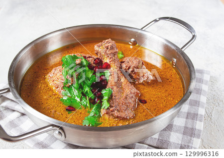 fesenjan, an Iranian dish, stewed chicken, in a nut-pomegranate sauce, in a saucepan,light background, homemade, no people, 129996316