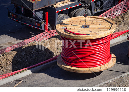 Big red cable coil, rises for installation at the city construction site, no people 129996318