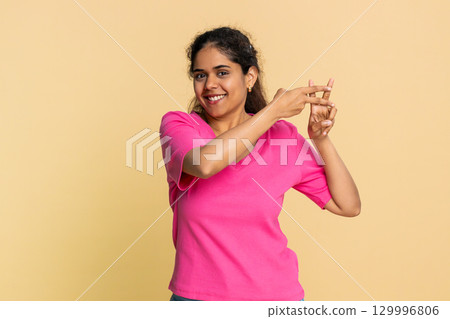 Indian woman gesturing hashtag symbol with fingers, playfully suggesting social media topic Indian woman gesturing hashtag symbol with fingers, playfully suggesting social media topic 129996806