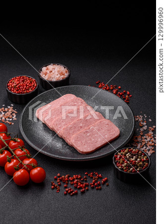 Food, meat, ham sliced in slices for the festive table. Spiced ham 129996960