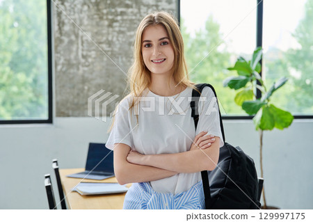 Portrait of student girl, positive smiling beautiful blonde with backpack looking at camera Portrait of student girl, positive smiling beautiful blonde with backpack looking at camera 129997175