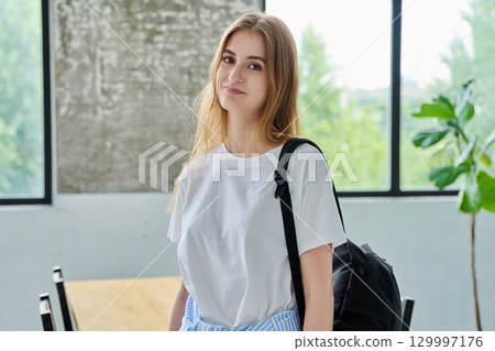 Portrait of student girl, positive smiling beautiful blonde with backpack looking at camera Portrait of student girl, positive smiling beautiful blonde with backpack looking at camera 129997176