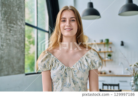 Headshot portrait young beautiful blonde female 18-20 years old in home interior 129997186