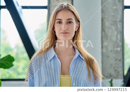 Headshot portrait young beautiful blonde female 18-20 years old in home interior 129997215