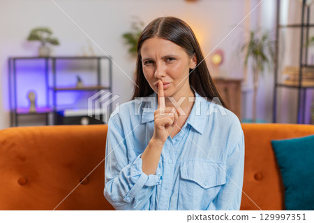 Woman presses index finger to lips makes silence quiet hush gesture sign do not tell gossip secret Woman presses index finger to lips makes silence quiet hush gesture sign do not tell gossip secret 129997351