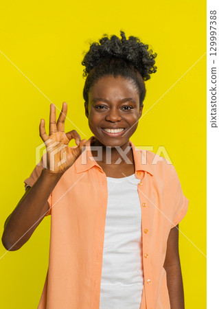 African American woman giving OK sign, slight smile positivity, confident gesture approval vibe African American woman giving OK sign, slight smile positivity, confident gesture approval vibe 129997388
